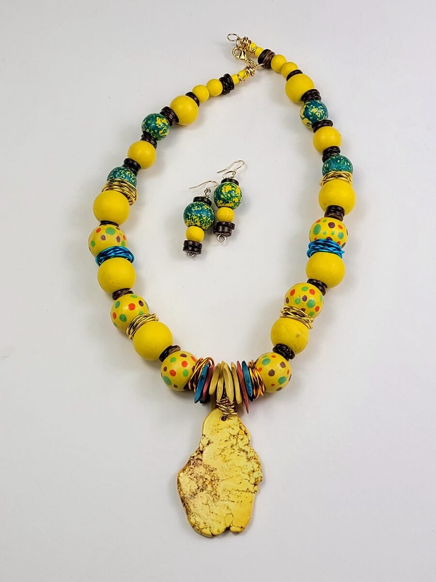 Bright yellow beaded necklace mixed with colorful polka-dot accent beads and a sun-yellow stone pendant.