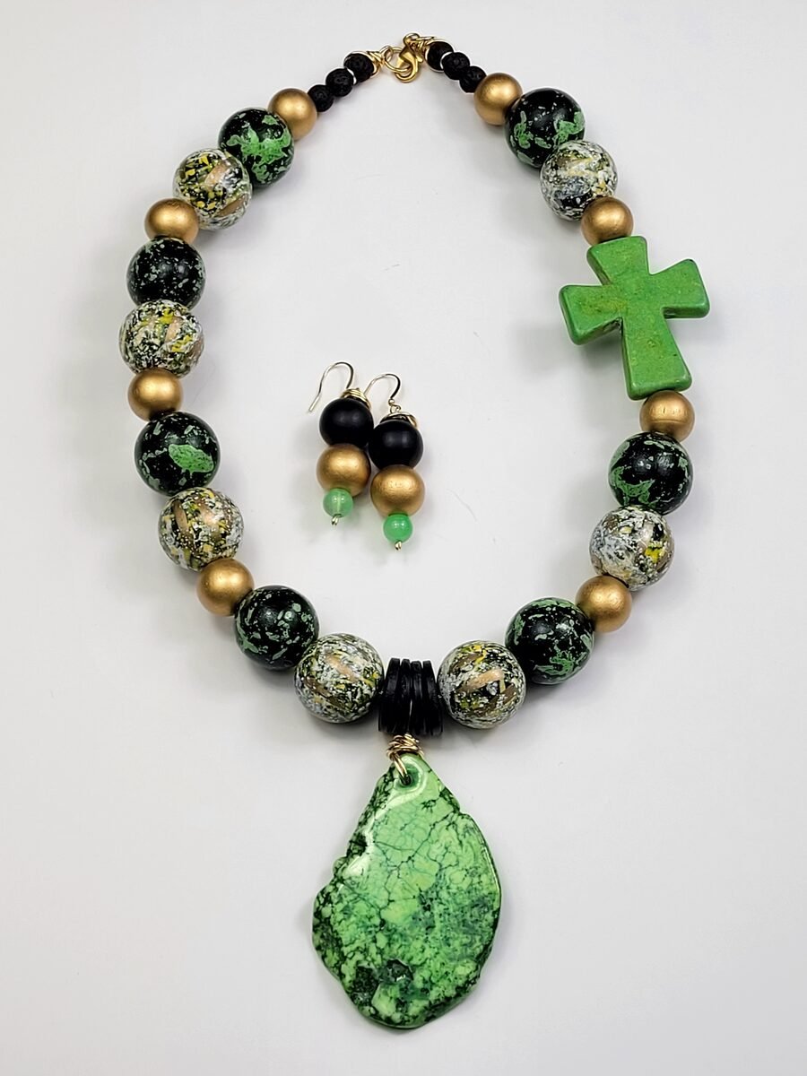 Black, green, and gold marbled necklace with a green turquoise cross accent and large green jade pendant.