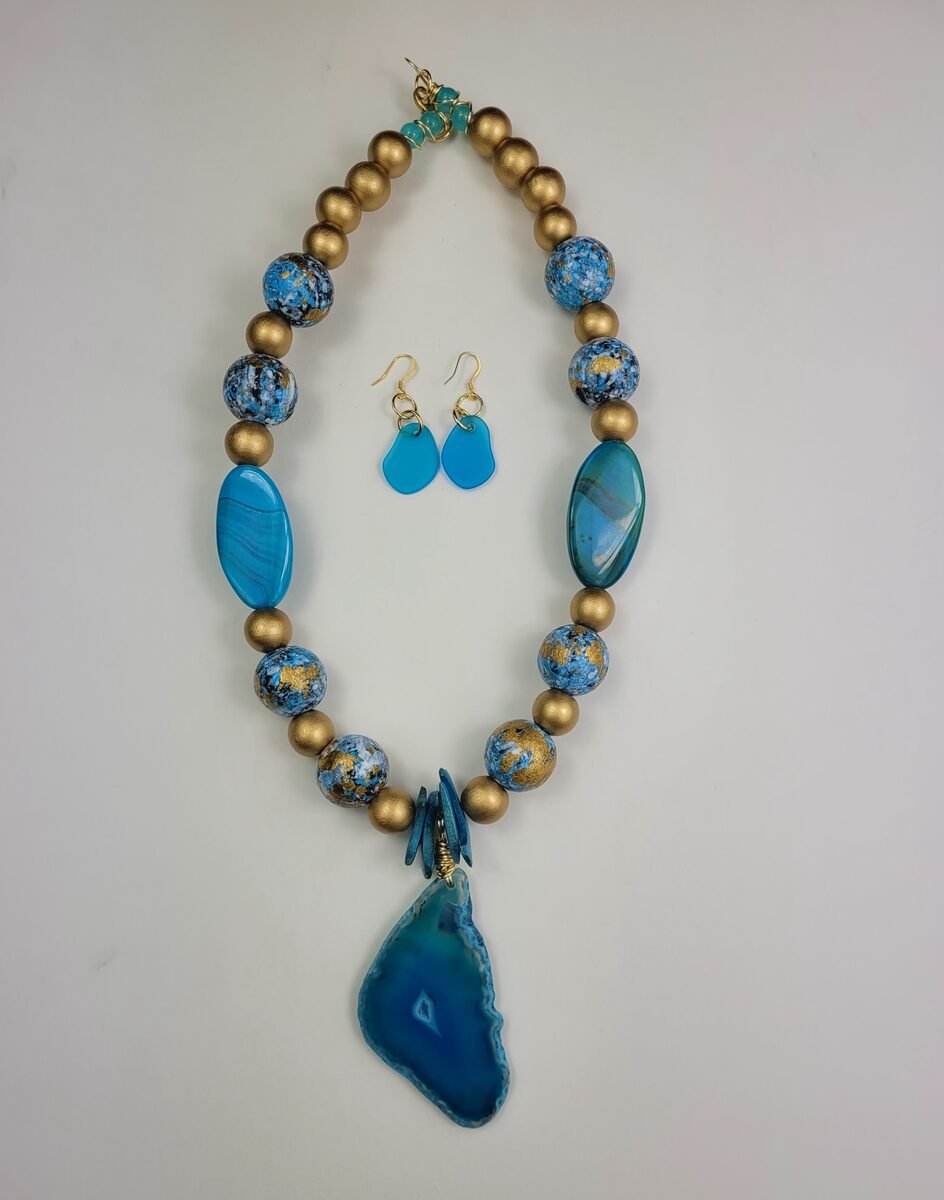 Turquoise beaded necklace with gold accents and an agate pendant.