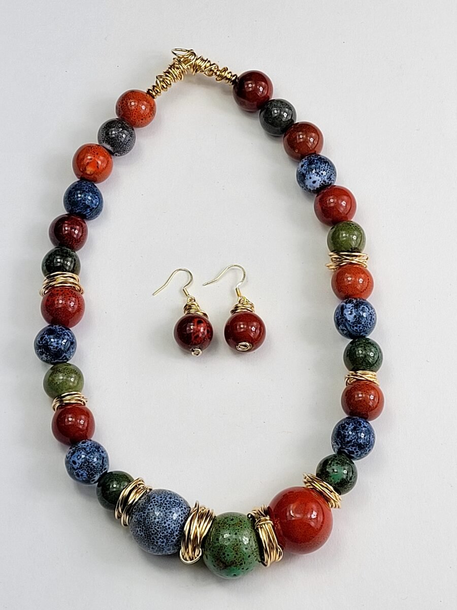 Multicolor speckled gemstone-style beaded necklace with gold wire accents.