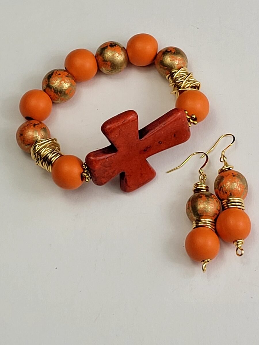Orange beaded bracelet with a cross charm.