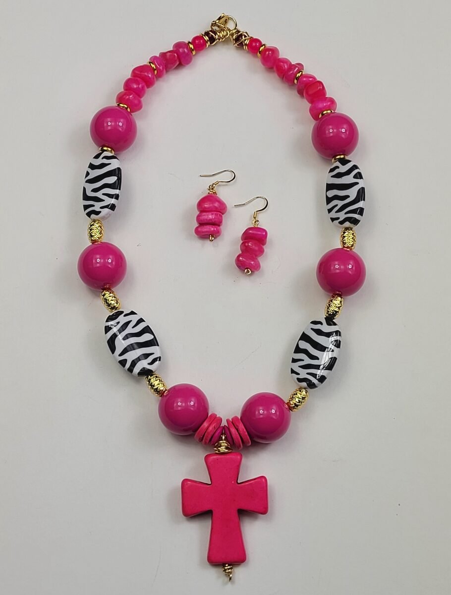 Bold hot pink beaded necklace with zebra-print oval beads and a pink cross pendant.